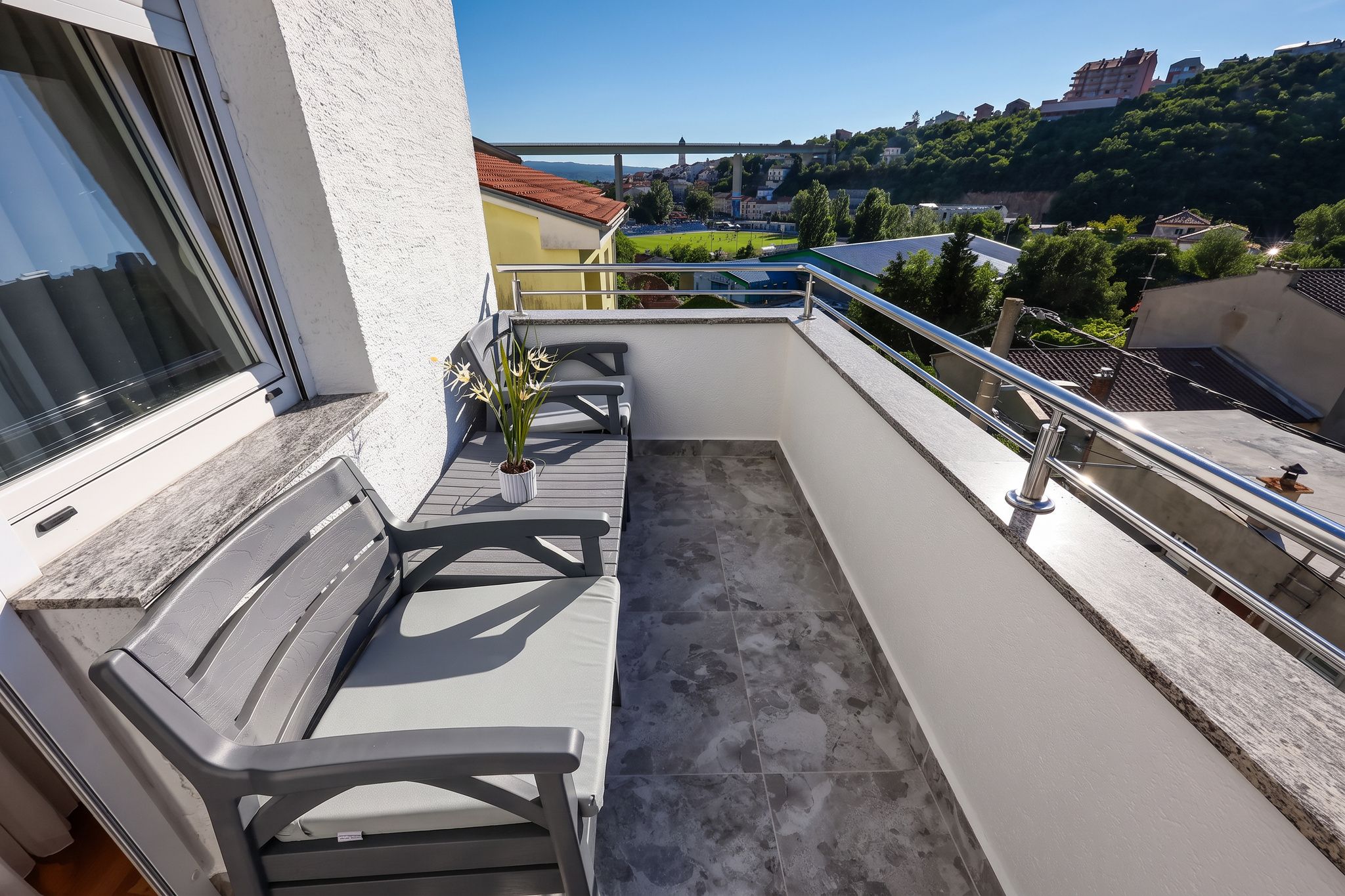 The long balcony of the two-bedroom, with bench seating and the town beyond