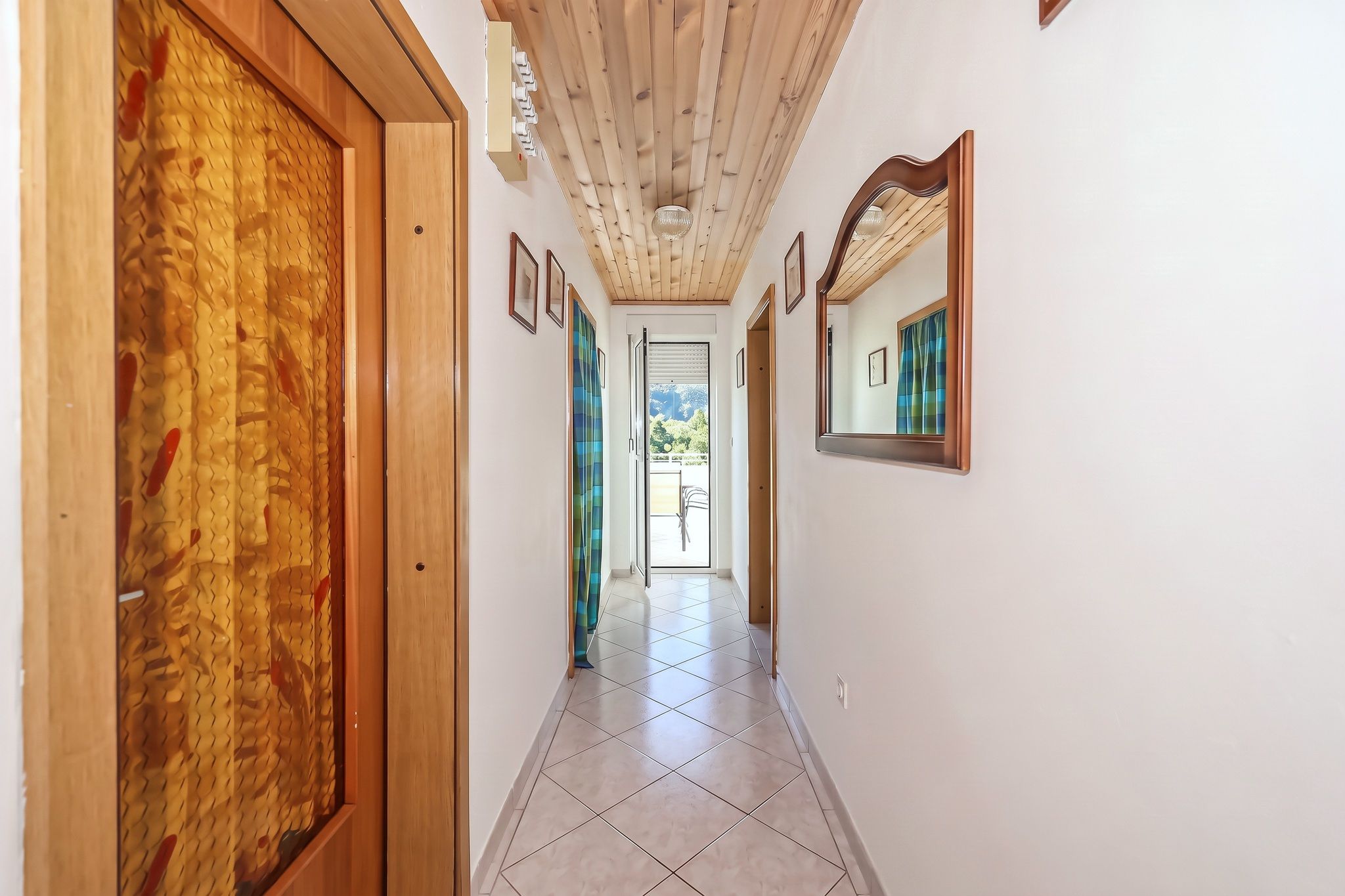 The hallway inside the four-bedroom, under its pine ceiling