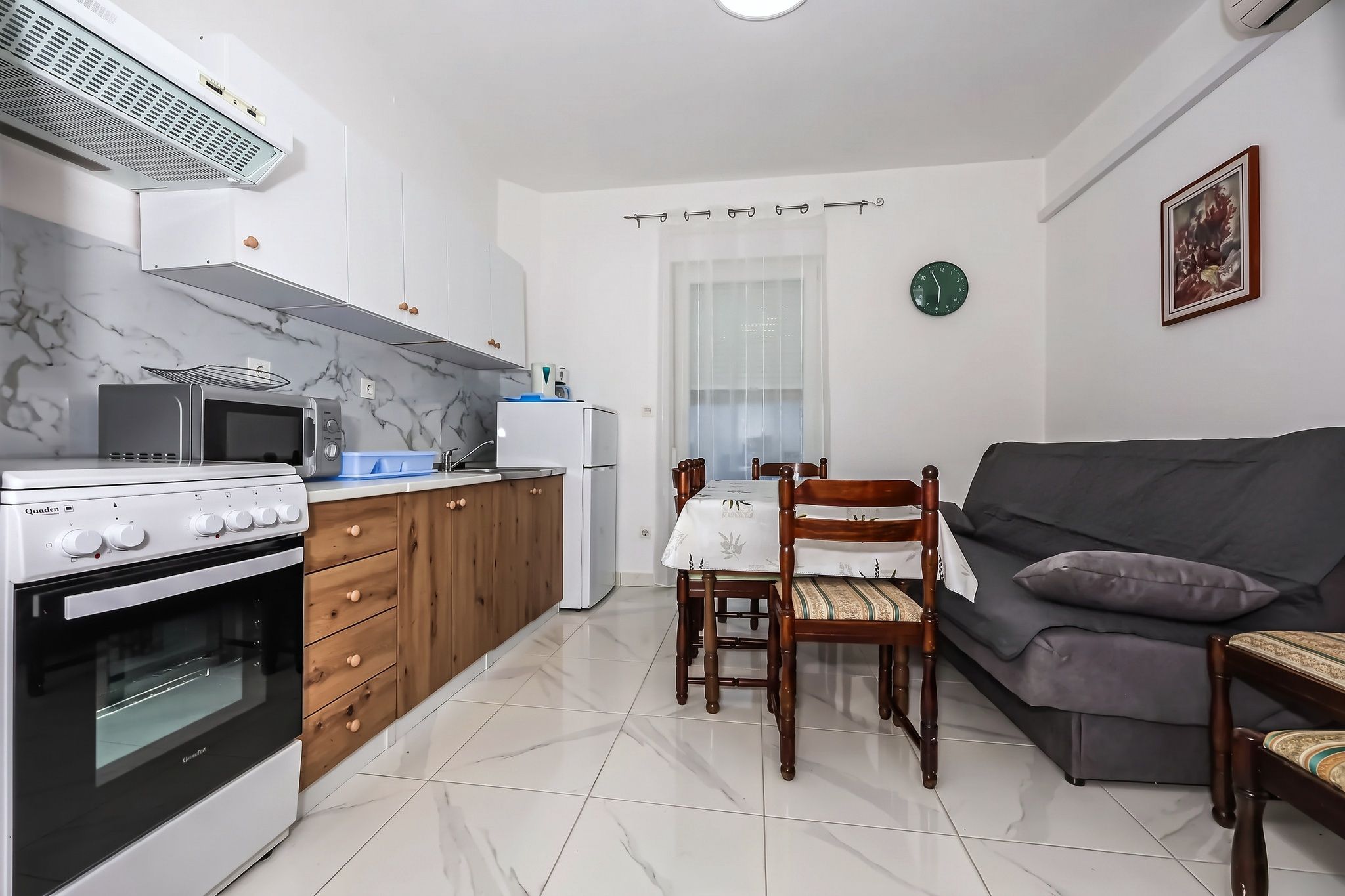 The living room and kitchen together, with the table and the sofa-bed