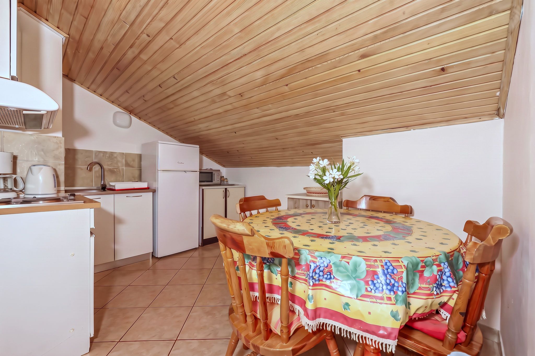 The four-bedroom's kitchen and dining table together under the pine ceiling