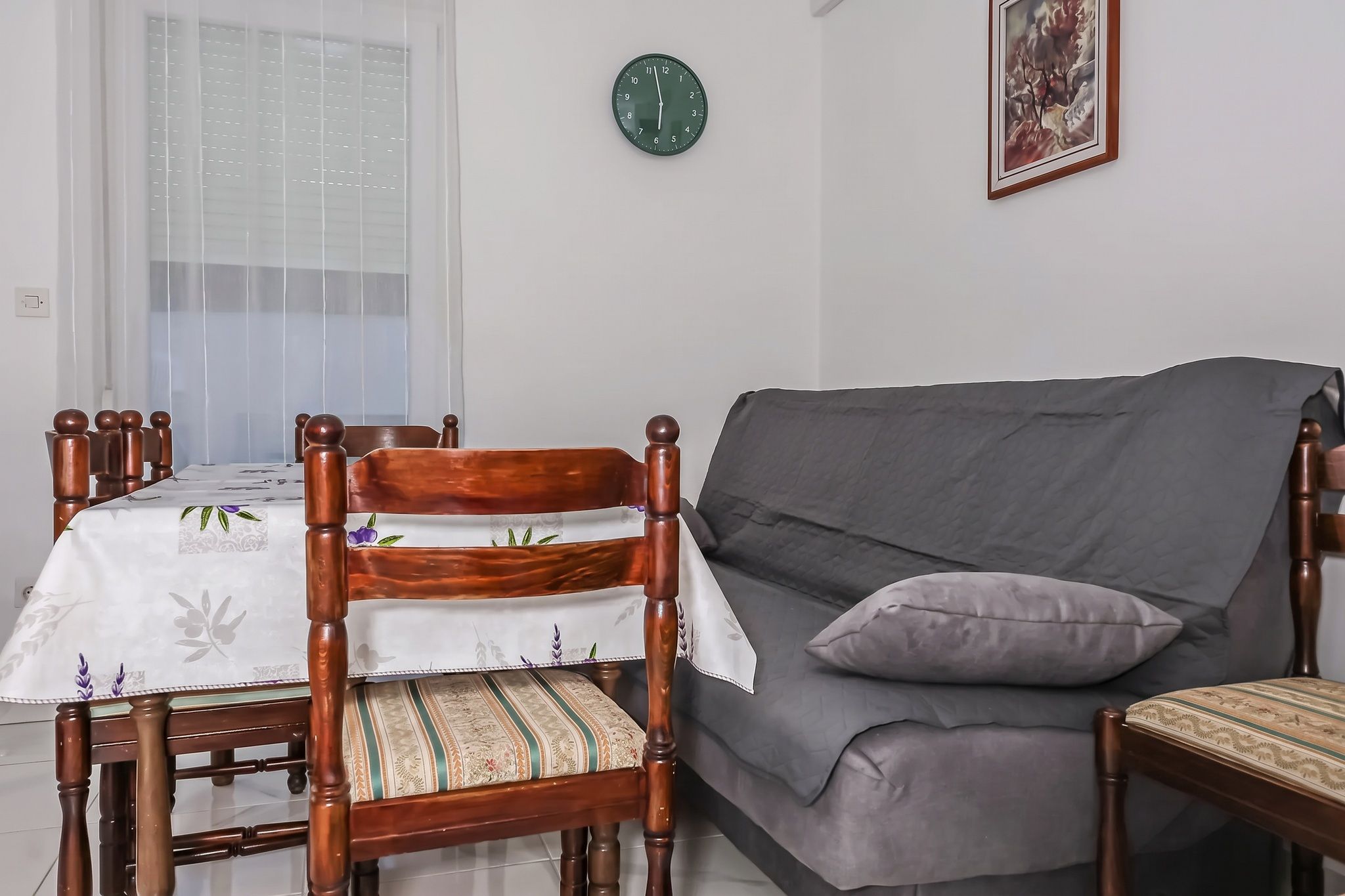 The dining corner, with the printed cloth and the grey sofa-bed