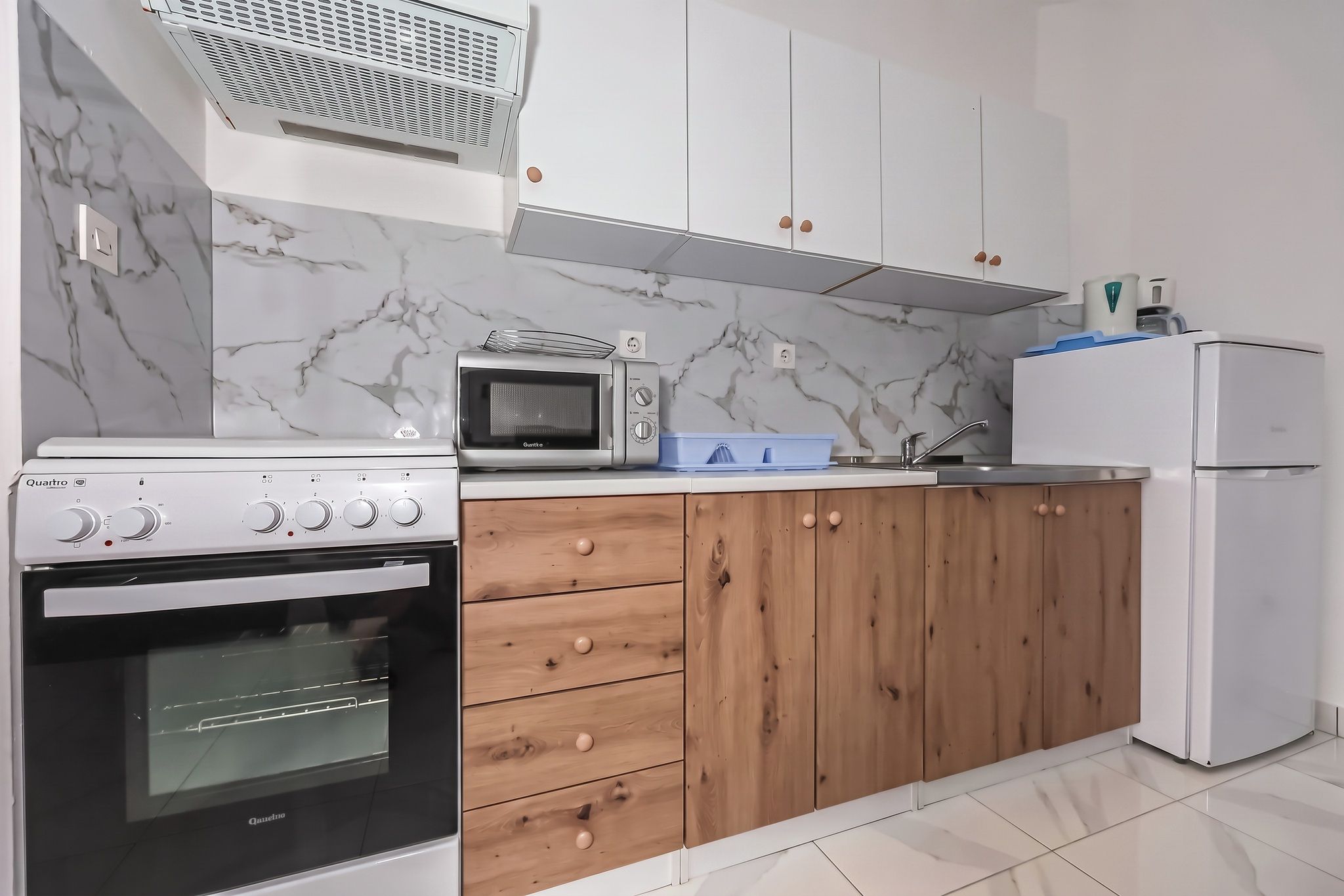 The kitchen run seen straight on, with the cooker and the oak-fronted units