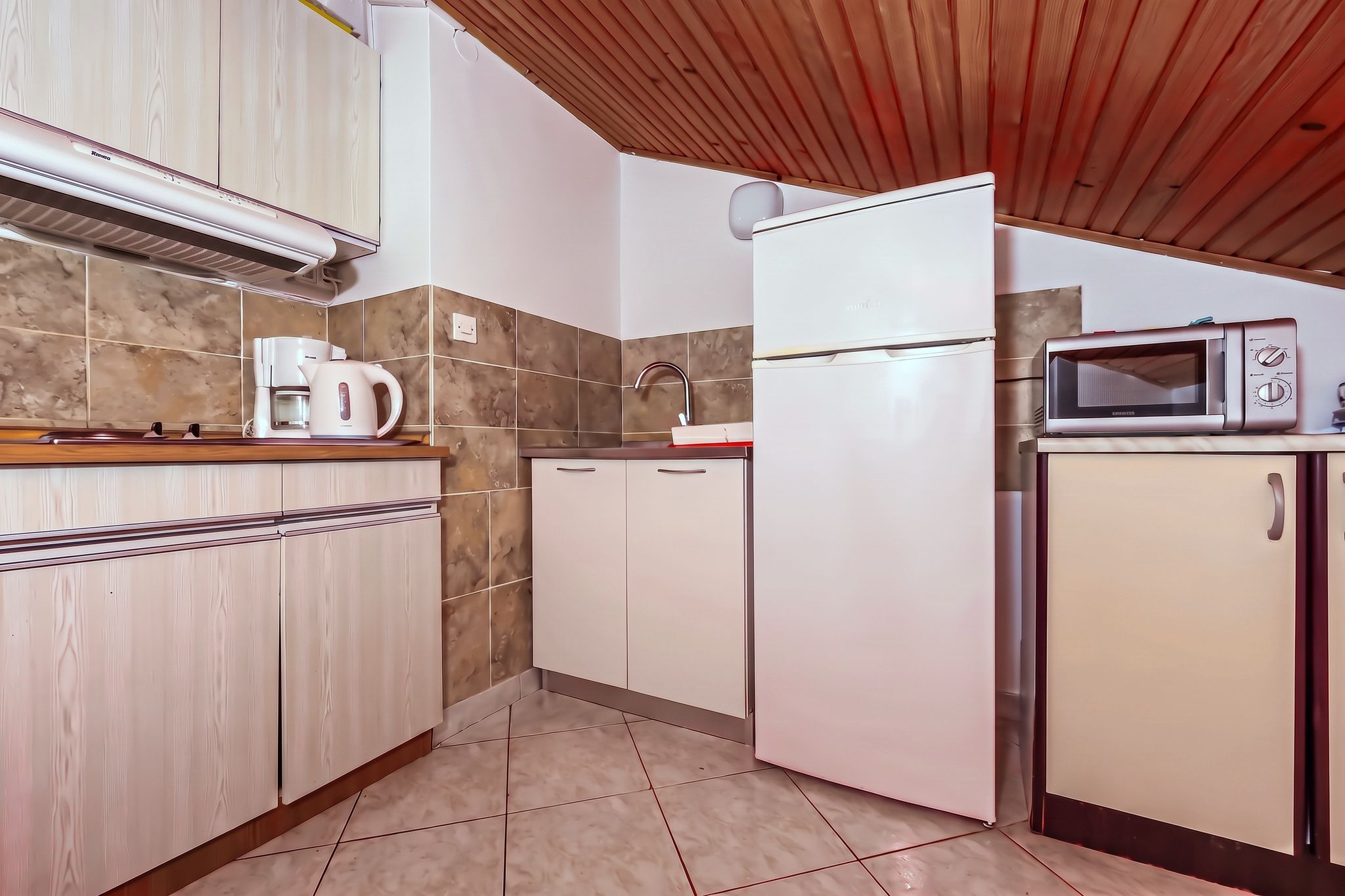 The four-bedroom's kitchen, with the hob, oven and tall fridge