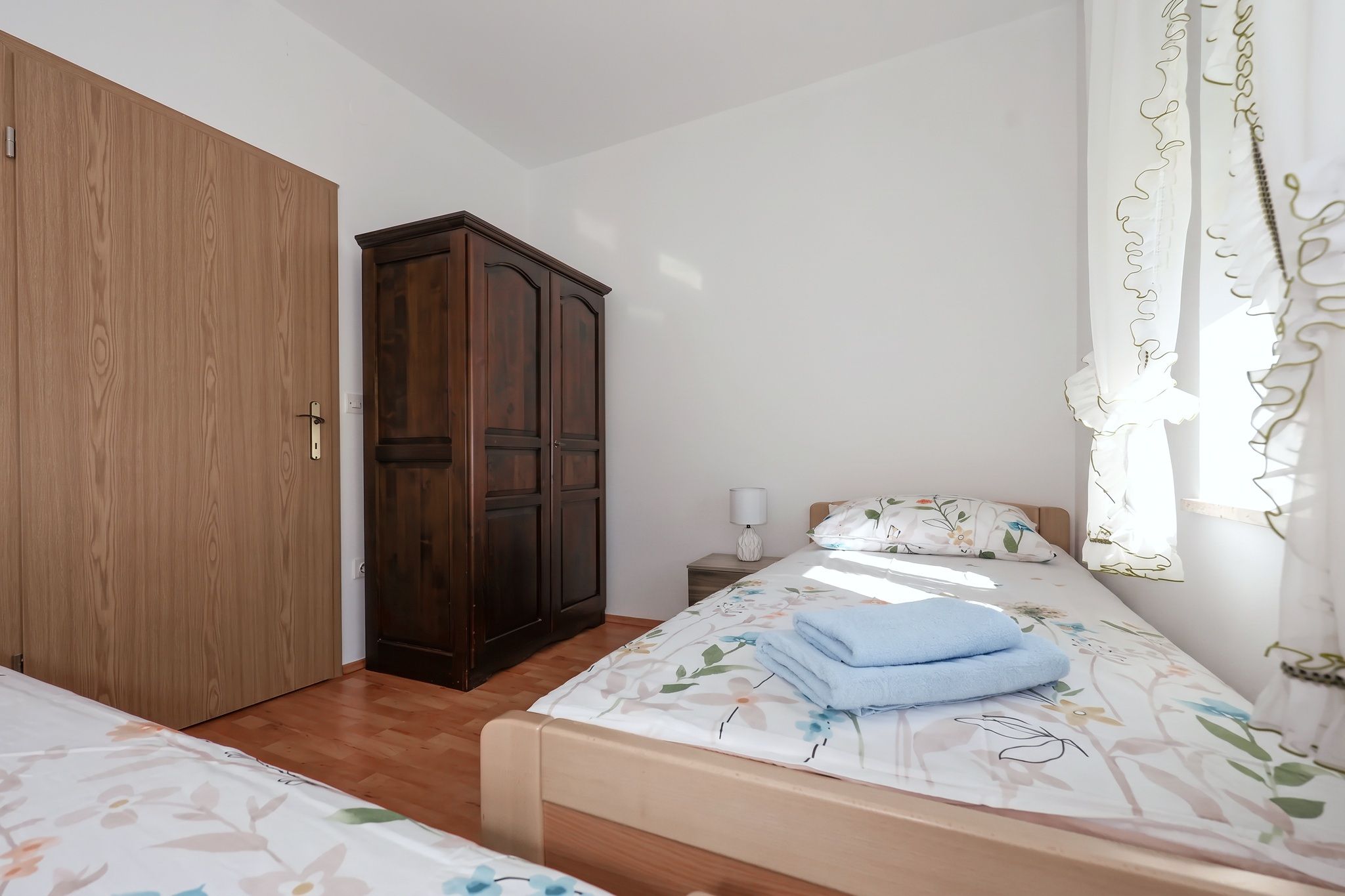 The second bedroom, with two single beds and a dark wardrobe
