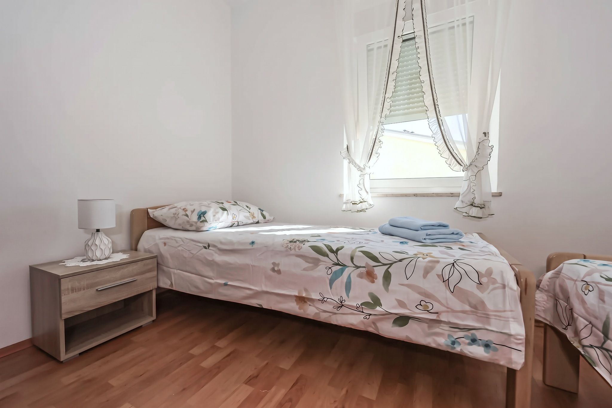 The second bedroom from the other side, with the bedside lamp and the window