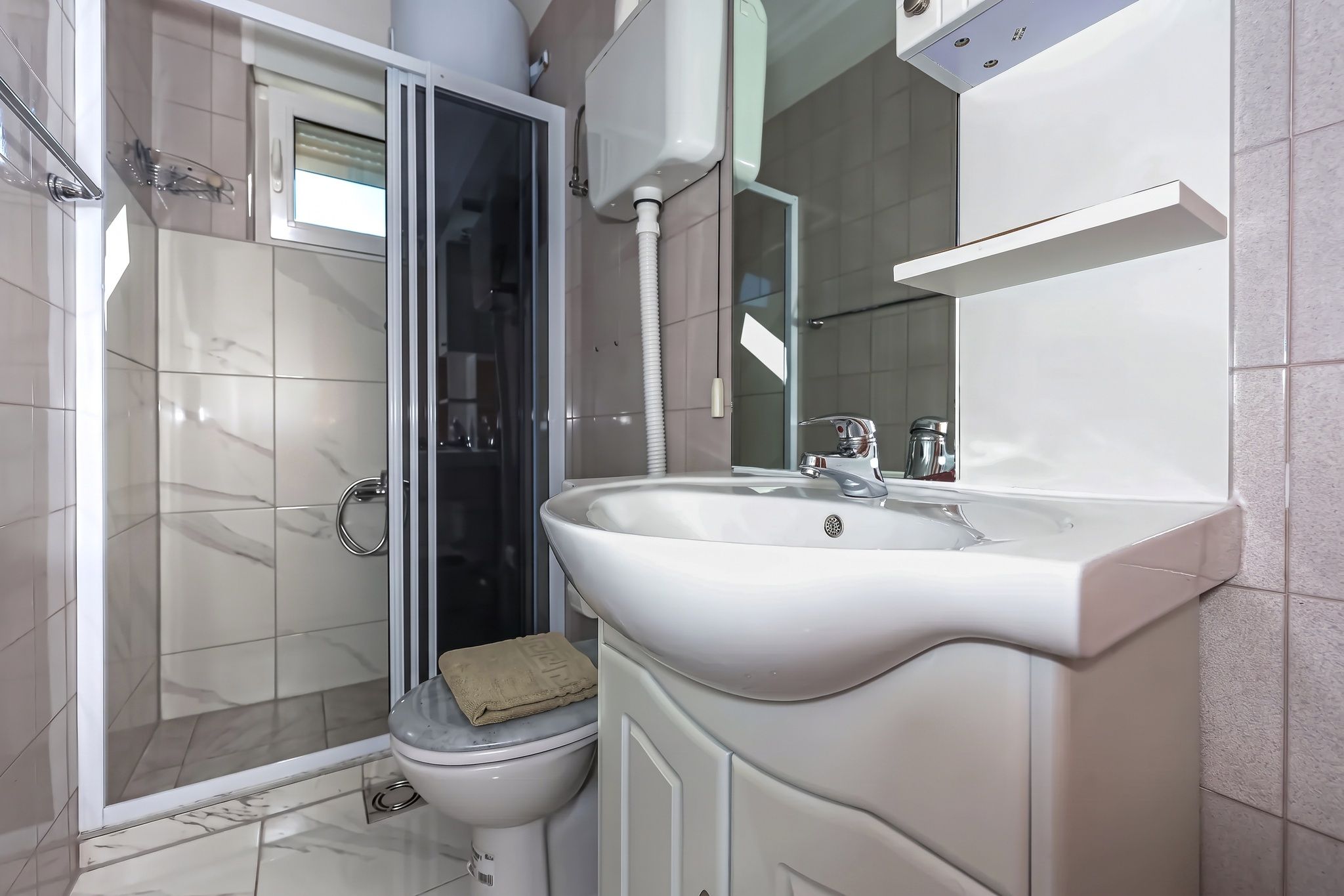 The bathroom of the two-bedroom, with a shower cubicle and a mirrored cabinet