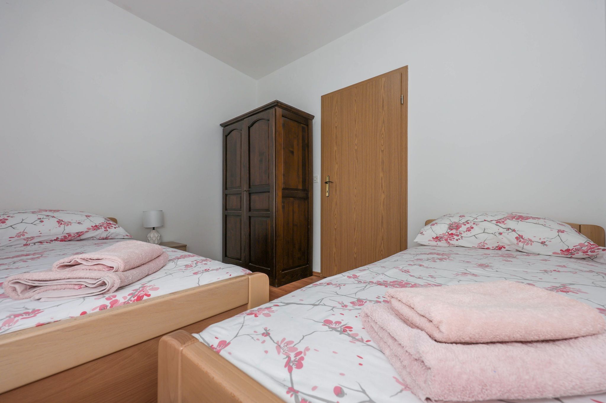 The second bedroom, with two beds and an oak door