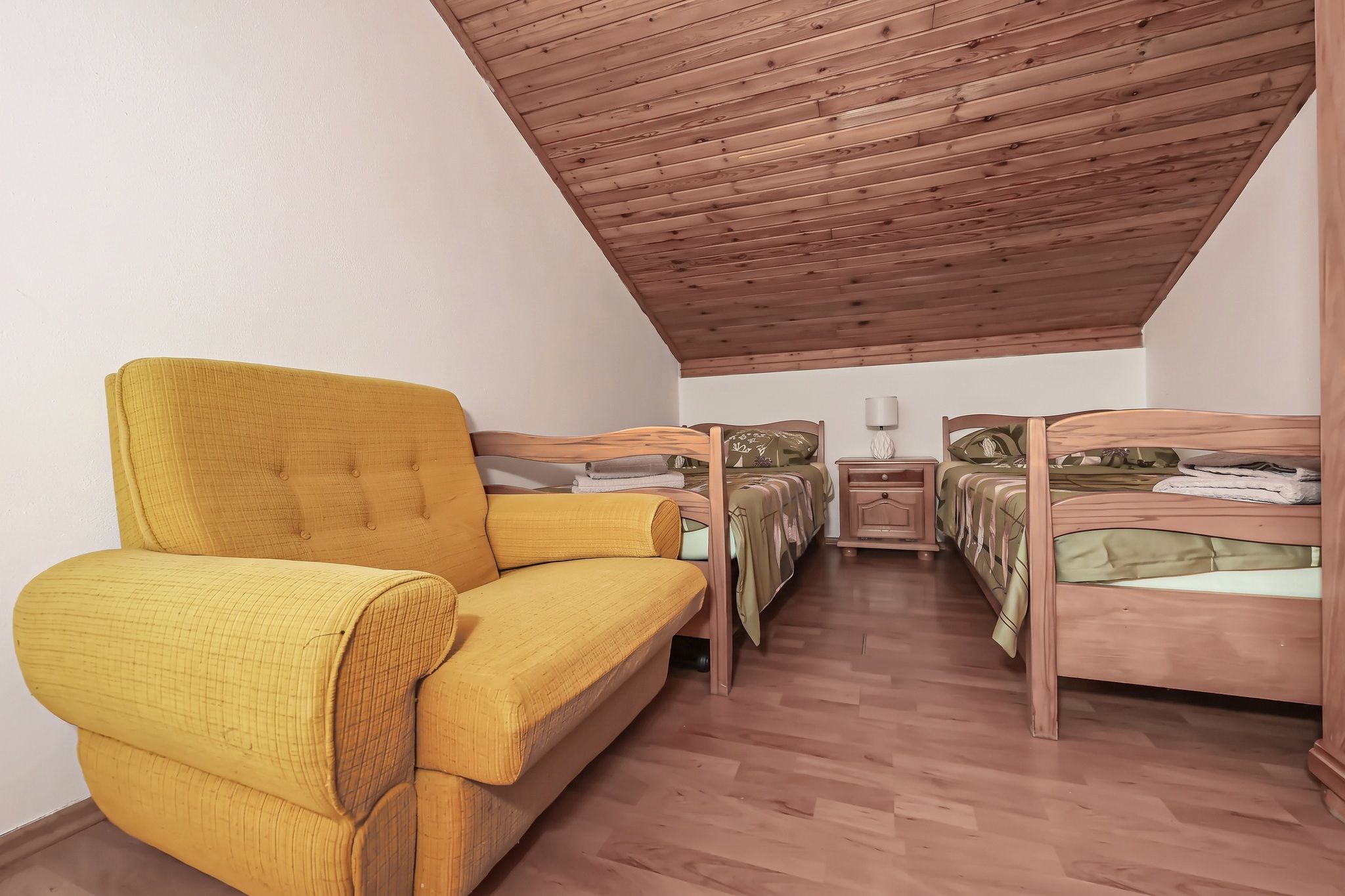 The second attic twin, with a mustard sofa under the slope