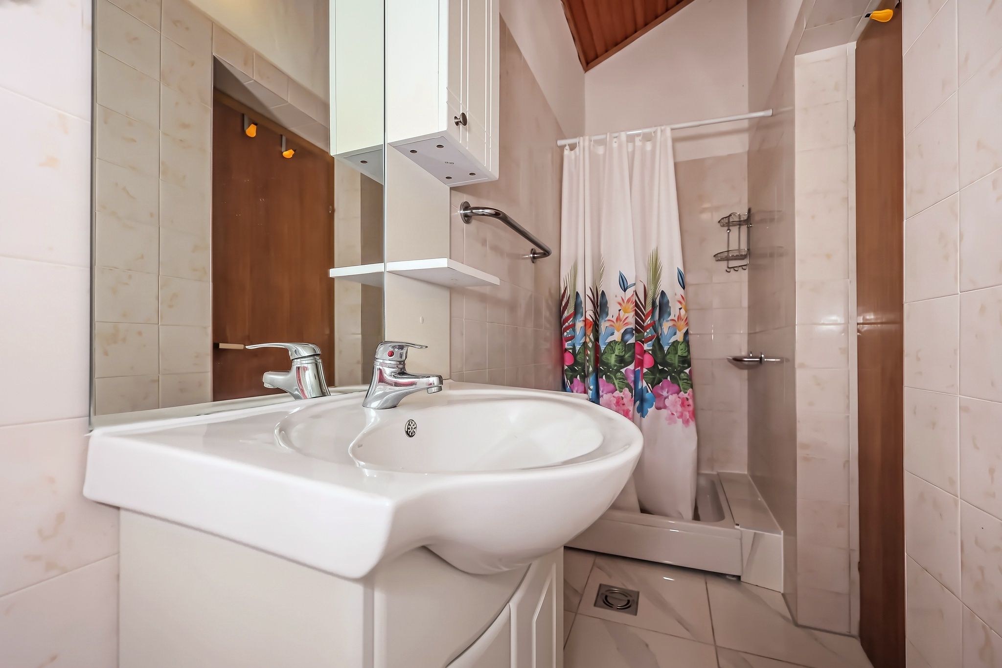 The four-bedroom's bathroom, with a basin, mirrored cabinet and shower