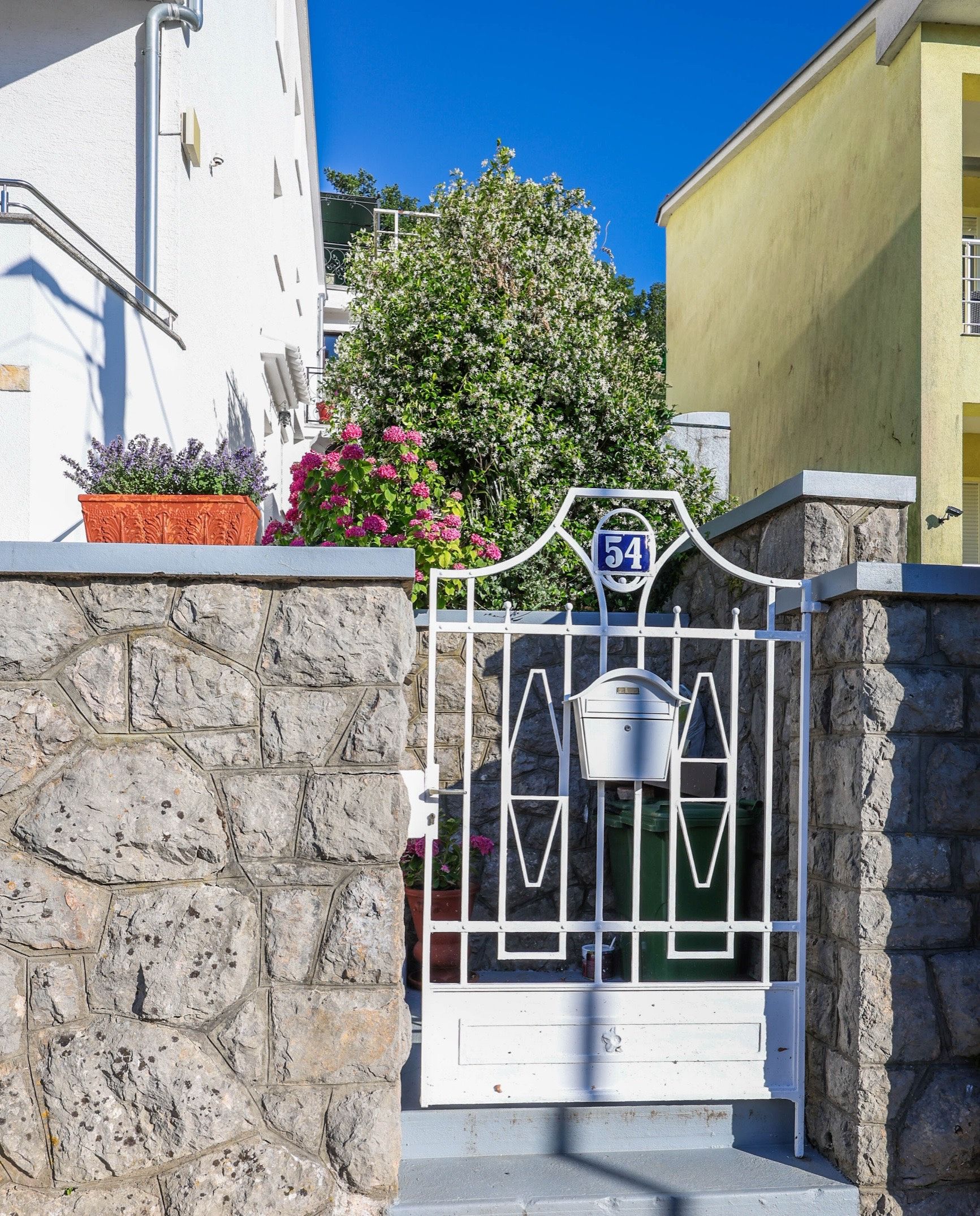 The gate at Kotorska 54, with the house number on a blue plaque